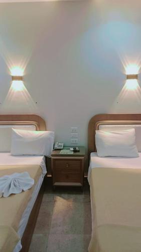 two beds in a hotel room with two lamps at فندق الصفا السياحي سوهاج in Sūhāj