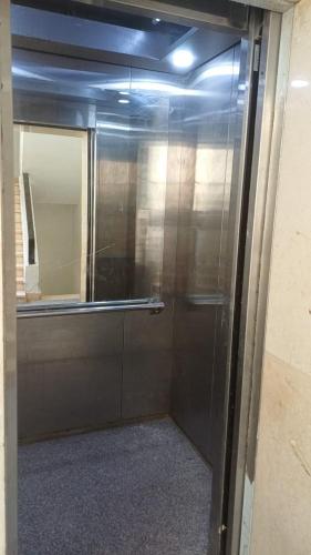 a glass door in a room with a mirror at فندق الصفا السياحي سوهاج in Sūhāj