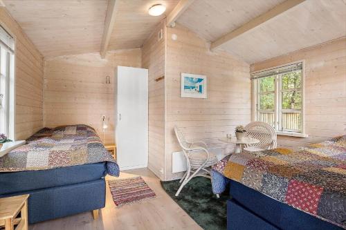 a bedroom with two beds and a table in it at LF16183-Logstor-Monasvej-1 in Løgstør