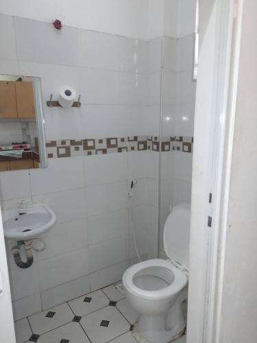 a white bathroom with a toilet and a sink at Cossy Homes in Mtwapa