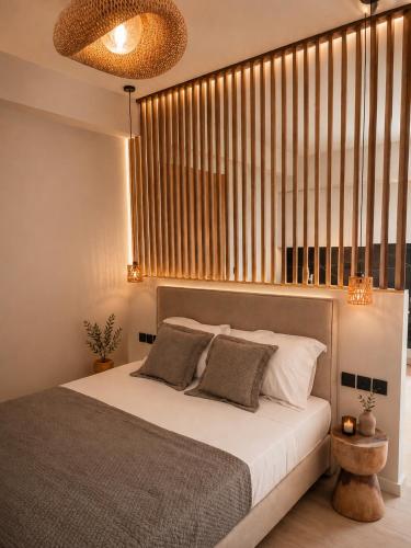 a bedroom with a bed and a large window at Milea amare Suites in Adamantas