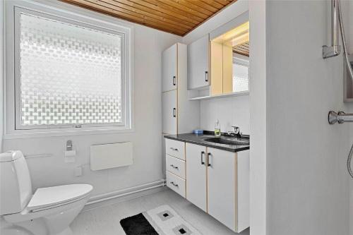 a bathroom with a toilet and a sink and a window at LF14221-Roslev-Astrup-Vig-81 in Roslev
