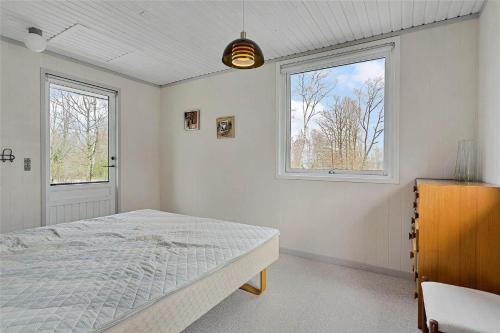 a white bedroom with a bed and a window at LF14221-Roslev-Astrup-Vig-81 in Roslev