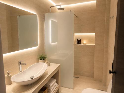 a bathroom with a white sink and a mirror at Milea amare Suites in Adamantas