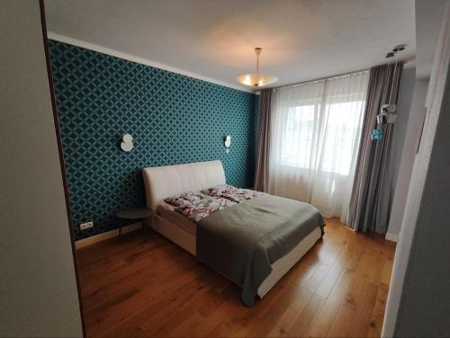 a bedroom with a bed and a blue wall at Stylish central apartment in Trenčín