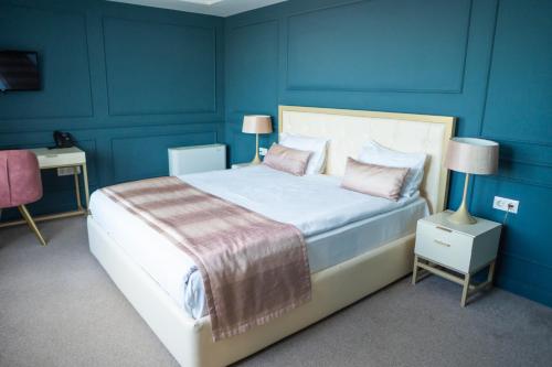 ein Schlafzimmer mit blauen Wänden und einem Bett mit rosa Kissen in der Unterkunft Monte Vedetta in Sliven