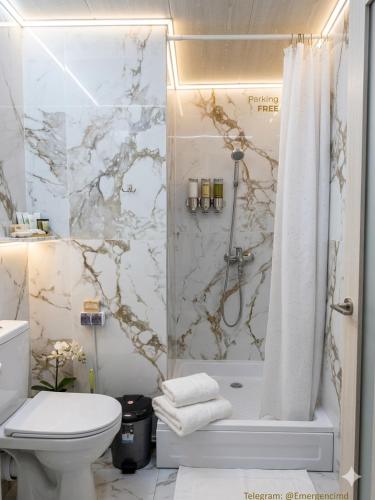 a white bathroom with a shower and a toilet at 31 August 1989 N 59 Hotel apart in Chişinău