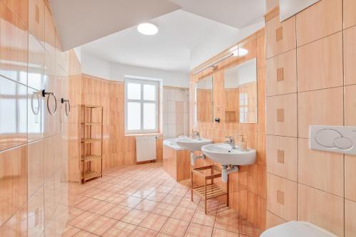 a bathroom with two sinks and two mirrors at Apartmány Nerudova in Vítkovice