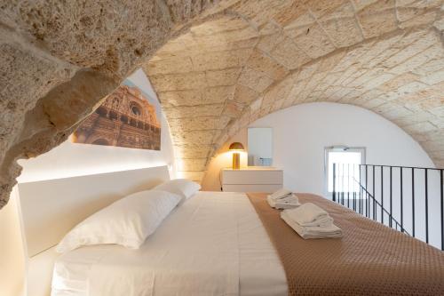 a bedroom with a large bed in a stone wall at Al Vecchio Cinema Martano in Martano