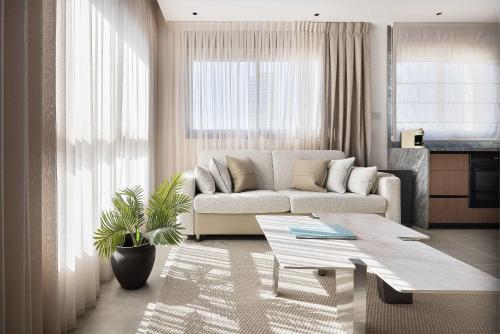 a living room with a couch and a table at 2BR Balcony High Floor - Dizengoff Square View - MAMAD D80 in Tel Aviv