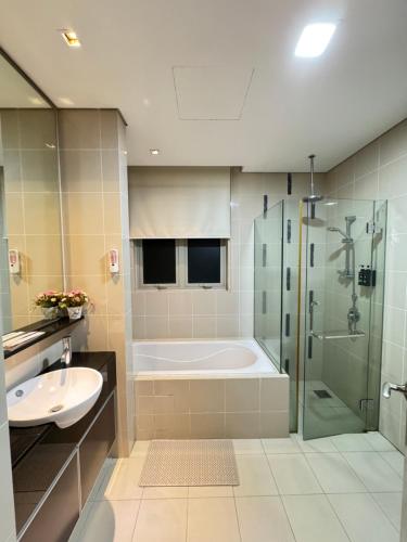 a bathroom with a tub and a sink and a shower at KLCC Marc Residence by AZ Line in Kuala Lumpur
