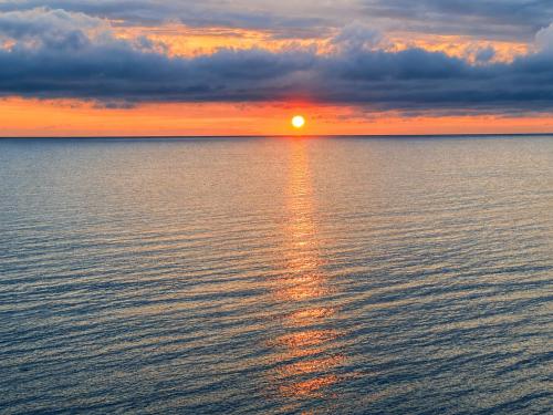 a sunset over a large body of water at ''Jūras Mala'' in Labrags