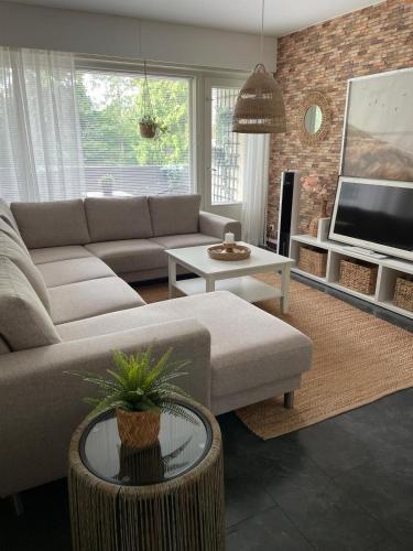 a living room with a couch and a tv at Yyterin Meriheinä in Pori