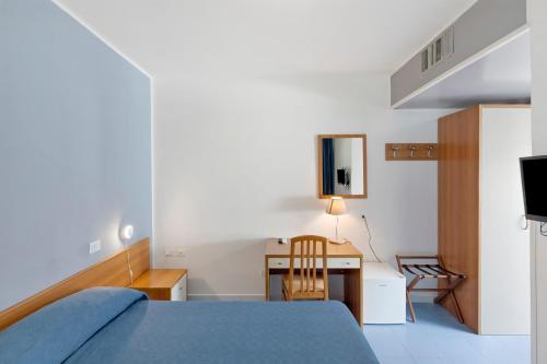 a bedroom with a bed and a desk and a television at Marina Living Rooms and Pool in Paestum