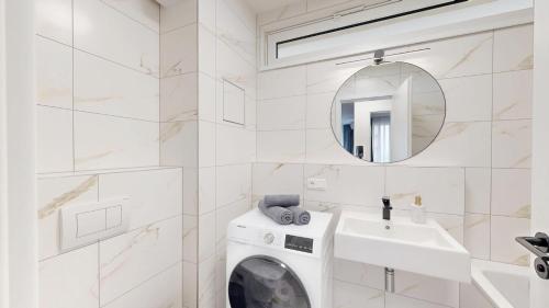 a white bathroom with a washing machine and a sink at Candy 3 in Trnava