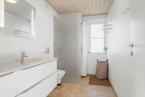 a white bathroom with a sink and a toilet at LF15113-Farso-Strandvejen-12-B in Farsø