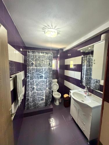 a bathroom with a black and white patterned shower curtain at Vila Mina in Ocnele Mari