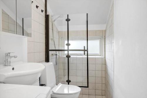 a white bathroom with a toilet and a sink at LF581-Hurup-Thy-Haettemagevej-1 in Sindrup