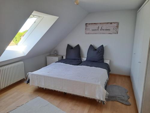 a bedroom with a bed with blue pillows and a window at Zum Nussbaum Wohnung Walnuss 86 qm 2 Schlafzimmer alles neu renoviert in Gerstetten