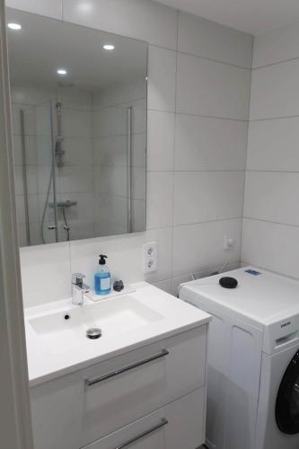 a white bathroom with a sink and a mirror at Modern Apartment Bergen Centrum in Bergen
