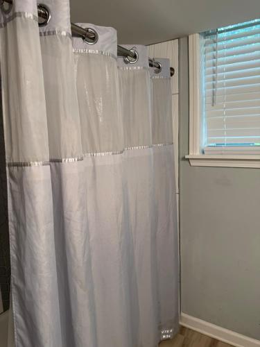 a white shower curtain in a bathroom with a window at Cozy ATL Suite with Kitchenette in Atlanta