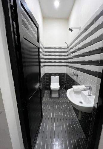 a black and white bathroom with a toilet and a sink at Hotel rahul prime in Gogameri