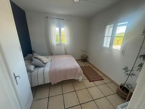 a bedroom with a bed and two windows at Apartment with mountain view in Espelette