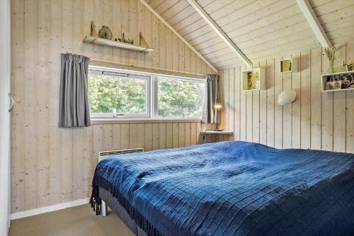 a bedroom with a blue bed and a window at LF328-Vestervig-Gunhildsvej-28 in Vestervig
