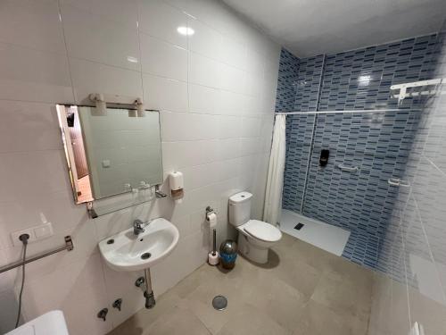 a bathroom with a sink and a toilet and a mirror at Hostal Rios in Bolonia