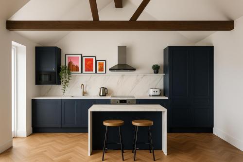 a kitchen with black cabinets and a counter with stools at The Bridge York in York