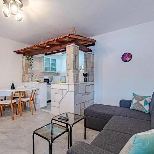 a living room with a couch and a kitchen at Apartmani Mila in Ubli