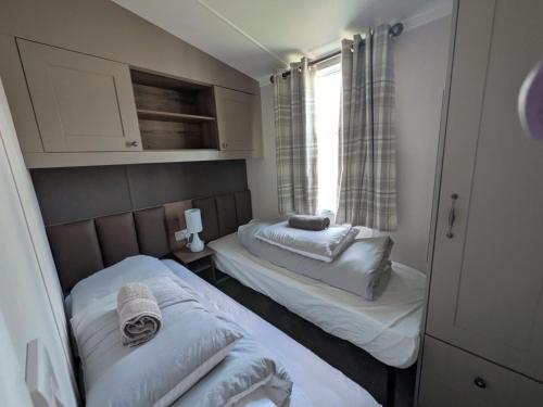 two beds in a small room with a window at Seaside Haven Hunstanton 2026 Model in Hunstanton