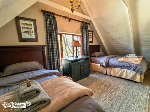 a bedroom with two beds and a desk in a room at Critchley Common in Dullstroom