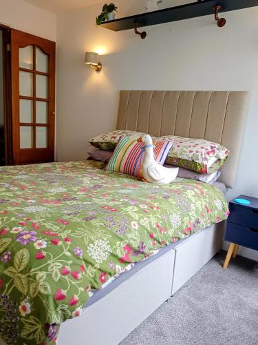 a bedroom with a bed with a green comforter at Rosemount Guest Suite in Grange Over Sands
