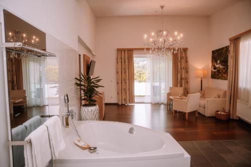 a large bathroom with a tub and a living room at Relax- & Wanderhotel Poppengut in Hinterstoder