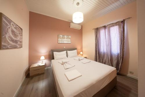 a bedroom with a large white bed and a window at Traditional House in Mytilene Center in Mytilene