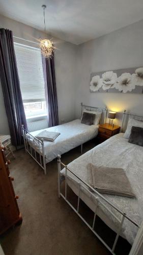 a bedroom with two beds and a chandelier at York city centre No7 Agar Street in York