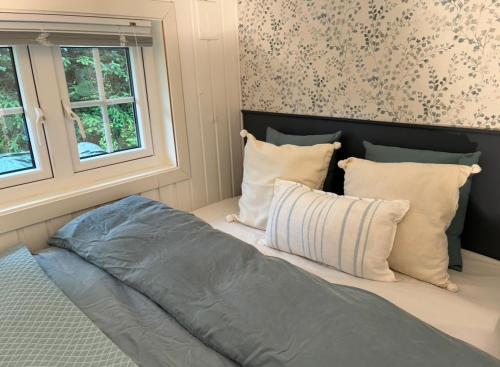 a bed in a room with pillows and windows at Tinyhouse surrounding Norwegian mountains in Bergen