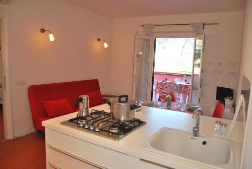 a kitchen with a sink and a stove top oven at Complesso La Foce - Clima, parcheggi, spazi esterni privati in Marina di Campo