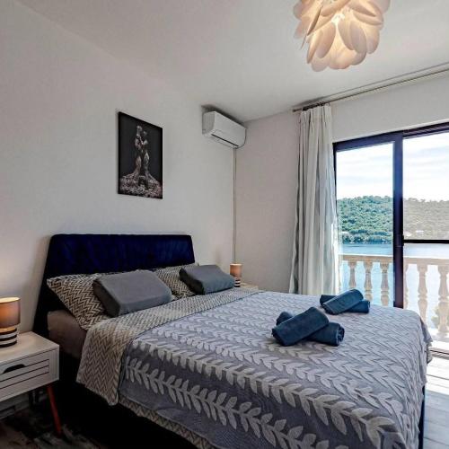 a bedroom with a bed with blue pillows on it at Apartmani Mila in Ubli