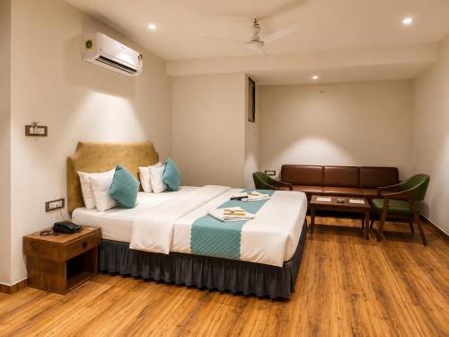a hotel room with a bed and a desk at Hotel Nee Residency in Rajkot