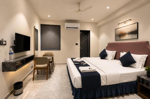 a hotel room with a bed and a flat screen tv at Hotel Nee Residency in Rajkot