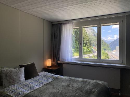 a bedroom with a bed and a window with a view at Studio Apartment Göschenen in Göschenen