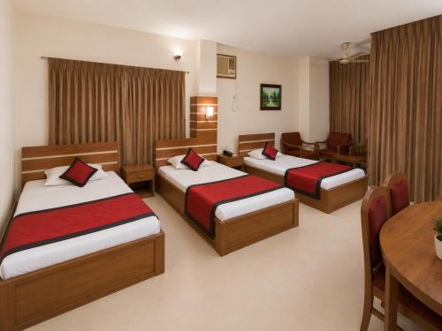 a hotel room with two beds and a table at Hotel Supreme in Sylhet