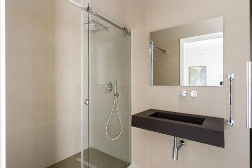 a bathroom with a glass shower and a sink at Aura - Stagnone Apartments in Marsala