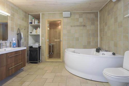 a bathroom with a tub and a toilet and a sink at 13328-Vig-Lillemosevej-5 in Vig