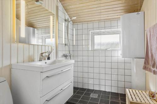 a white bathroom with a sink and a mirror at LF320-Hurup-Thy-Skraningen-9 in Doverodde