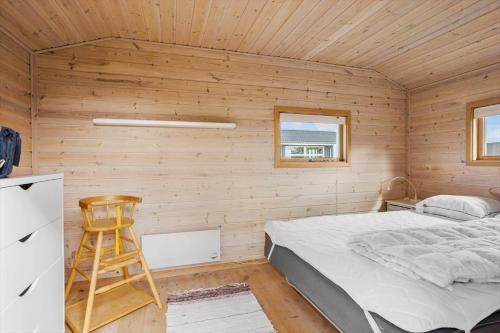 a bedroom with a bed and a wooden wall at LF320-Hurup-Thy-Skraningen-9 in Doverodde