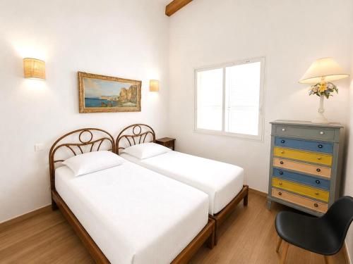 a bedroom with two beds and a dresser and a window at Villa d'exception sur la plage - Tizzano in Sartène