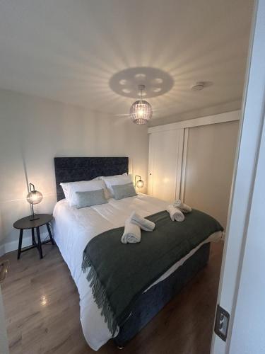 a bedroom with a large bed with two towels on it at Village Centre Haven in Clifden